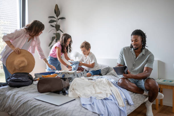istock Diverse Family Engages in Packing for Trip With Technology Aid 2166530599