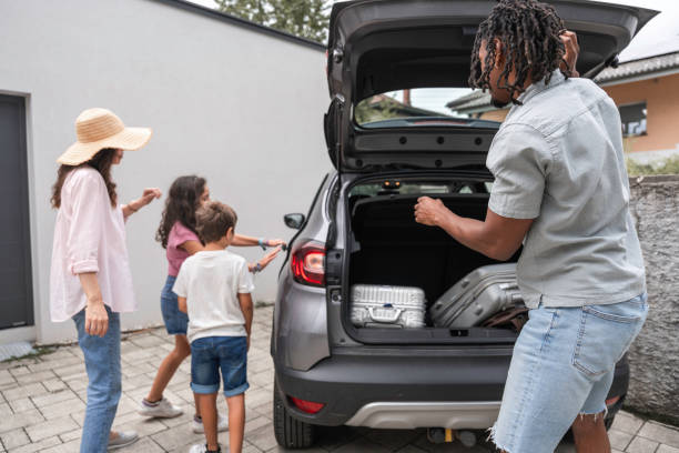 istock Diverse Family Prepares for Vacation Loading Car 2166530719