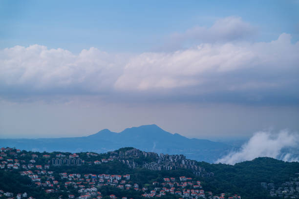 White clouds moved quickly over the residential areas on the hillside. The scene is dominated by clouds, creating a sense of dynamics and energy. New Taipei City, Taiwan.