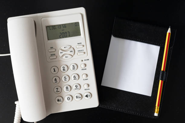 Office Desk Essentials: A Phone, Notepad, Pencil, and Keyboard on a Workspace, Featuring Digital Communication Tools and Stationery for Efficient Note-Taking and Texting