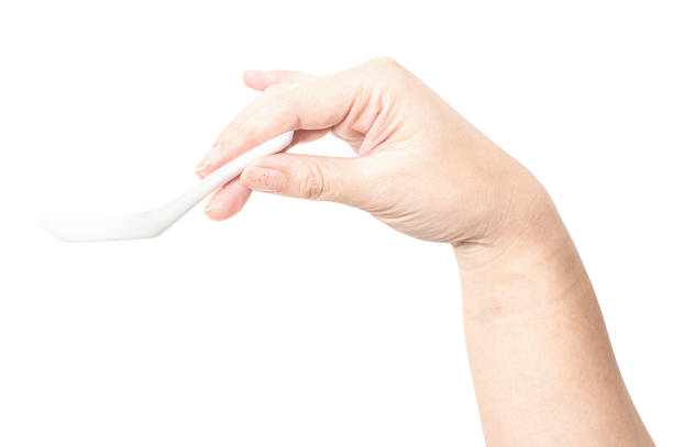 istock Female hand holding a white plastic spoon isolated on white background. 2166538465