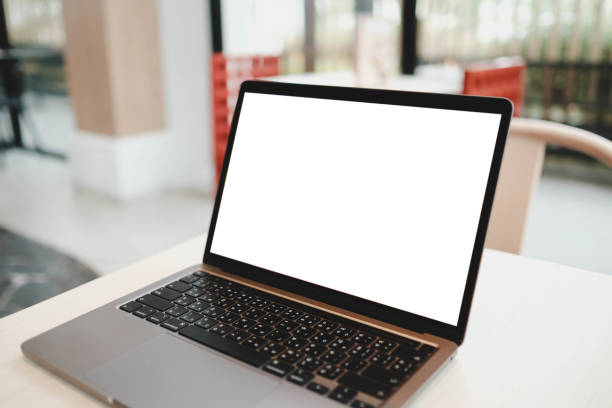 istock Wooden table with laptop white screen complemented by a cafe shop blurred background. 2166542631