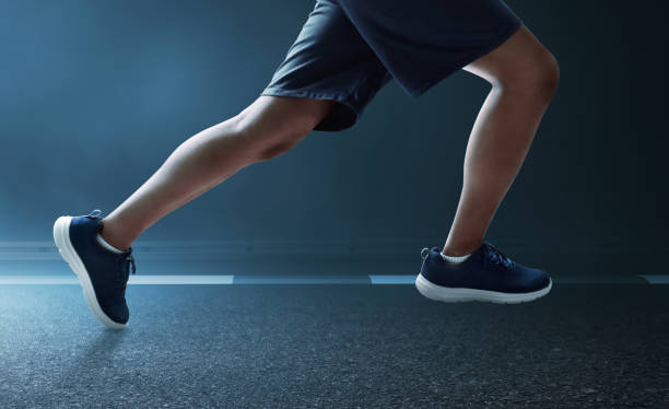 istock Young man runner legs sprinting at dark night with smoke 2166545046