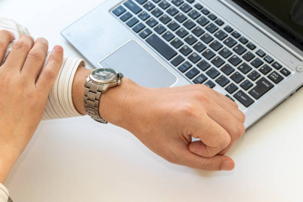 istock Man looking at his watch while working in the office 2166548882
