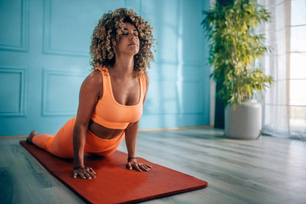 istock Young woman taking exercise in her living room. 2166549401