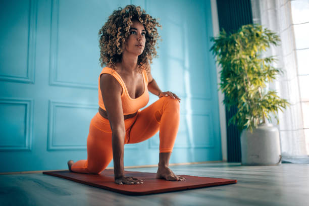 Young woman taking exercise in her living room.