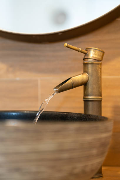 istock Luxury designed brass faucet with water flowing. 2166554445