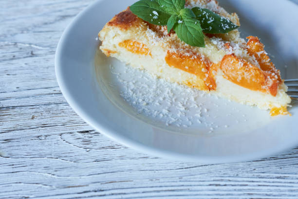 Cottage cheese cake with apricot and mint on white plate
