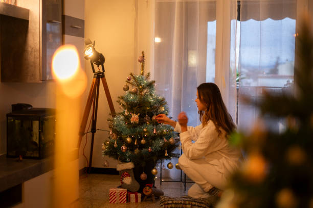 istock Girl in white pajamas setting up the Christmas tree 2166560879