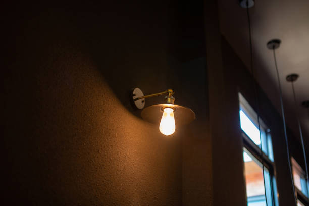 istock Black wall lamp with orange bulb. 2166561581