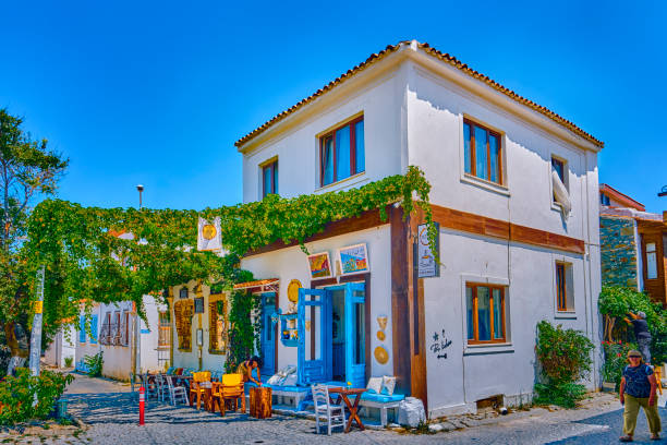 Bozcaada, Turkey, July 18, 2024, Colorful streets with old beautiful houses and bright flowers, tourists walk along the streets of the island