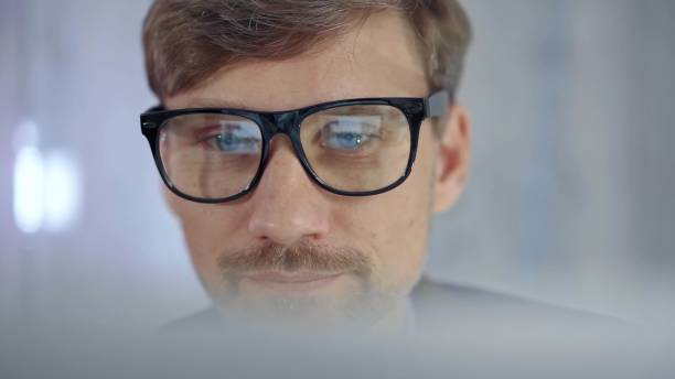 istock Businessman with glasses looking intently obscured partially by a translucent surface of laptop. Business concept 2166566725