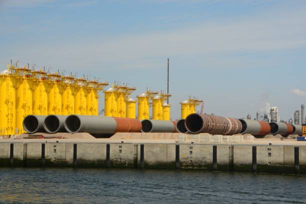 Rotterdam-Netherlands / 6 august 2024; Maasvlakte 2 Large steel pipe shafts laying on the Quayside. Construction industry fore offshore wind turbine. Visible brand name and numbers.