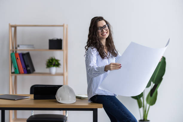 istock Young female architect working with home drawing plan on blue print with architect equipment in the office 2166568834
