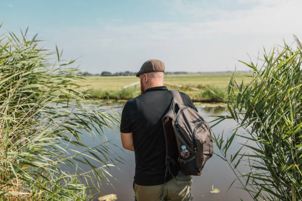 Active senior birdwatching handsome man enjoying a new hobby outside in the Netherlands