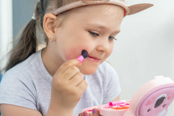 istock Adorable little girl applying makeup using children's cosmetics 2166569628