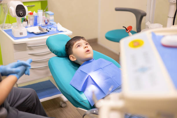 istock kid in dental office. dentist checking child teeth using tools mouth mirror and scalar.crying with tears, sad boy is afraid.doctor looking at screen,tooth filling treatment.kid in chair being examined 2166570458