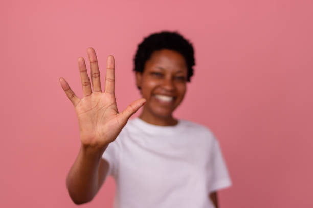 istock Smiling young woman showing open hand on pink background 2166570466
