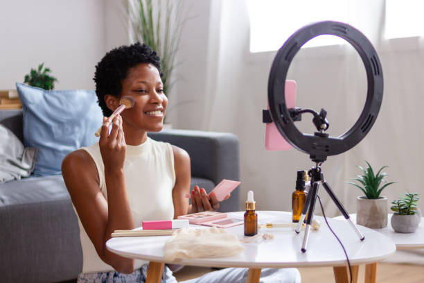 istock Beauty influencer applying makeup using smartphone on tripod with ring light 2166570507