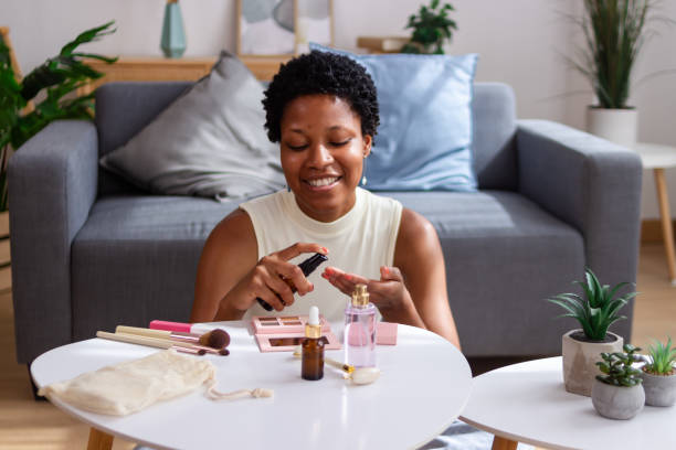 istock Smiling young woman applying moisturizer on her face at home 2166570589