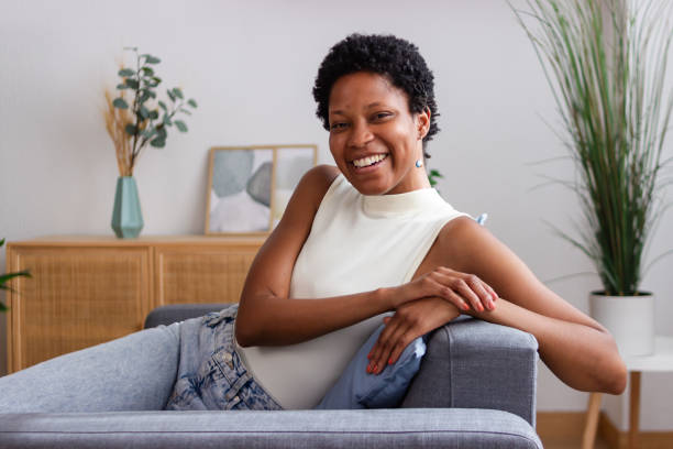 istock Young black woman relaxing on comfortable sofa at home smiling 2166571666