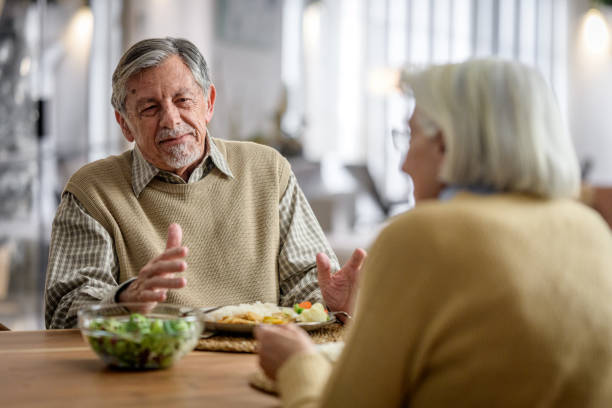 istock Senior Couple Enjoys Cozy Dinner at Home 2166571739