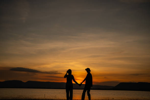 istock A couple is holding hands on a beach at sunset 2166572554