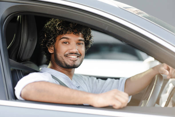 istock Young Indian man smiling and driving a modern car 2166572579