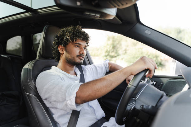 istock Young man driving a car and holding steering wheel 2166572608