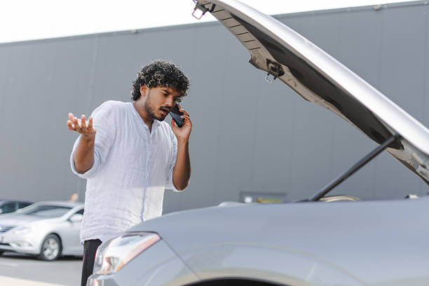 istock Frustrated young man calling for assistance with broken down car 2166572616