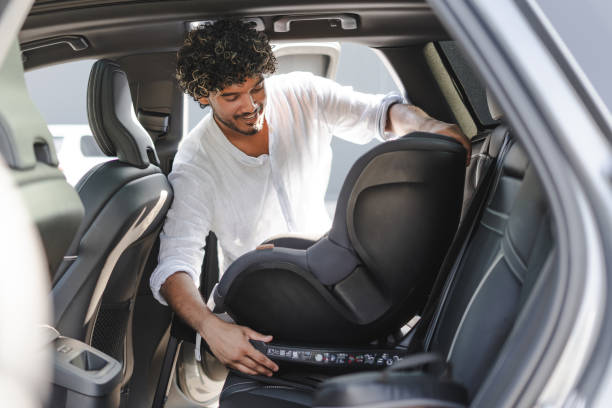 istock Father installing baby car seat in modern vehicle 2166572621