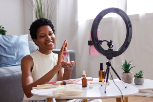 istock Smiling beauty influencer applying perfume while recording video content 2166572869