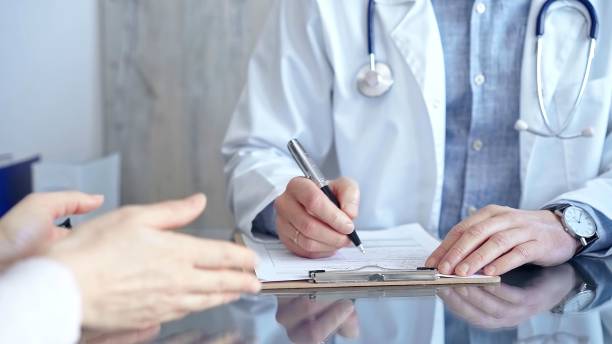 istock Doctor and patient conversation with clipboard in clinic office. Physician is making notes while listening woman. Medicine and Health care 2166572965