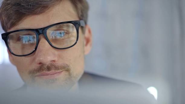 istock Businessman with glasses looking intently obscured partially by a translucent surface of laptop. Business concept 2166578328