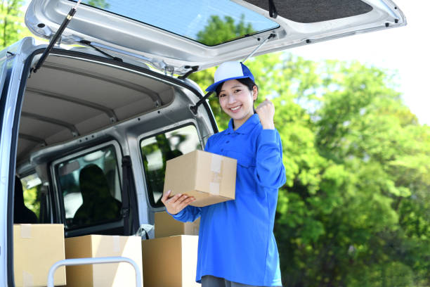 istock An Asian female delivery driver makes a fist pump while holding a package. 2166578966