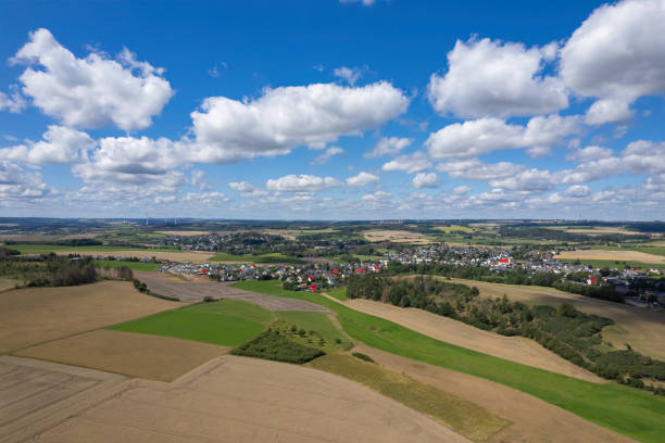 istock small village with a wind turbines on a horizon (aerial) 2166581244