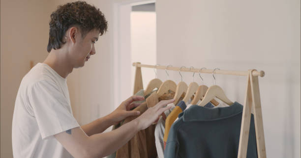 istock Man Choosing Clothes from Clothes Rack. 2166582215