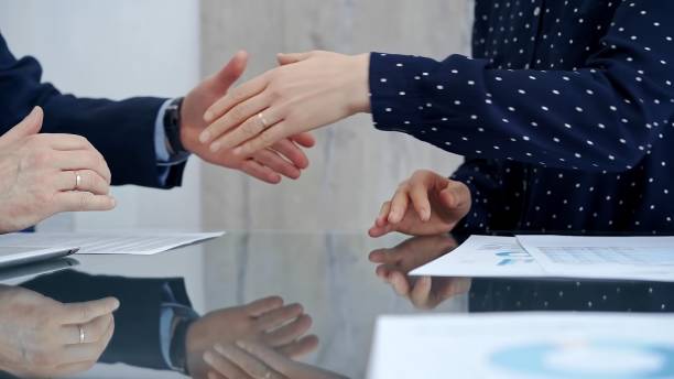 istock Professional handshake between two professionals and applauds at a corporate meeting with reflection on table over a business meeting. Business people concept 2166582424