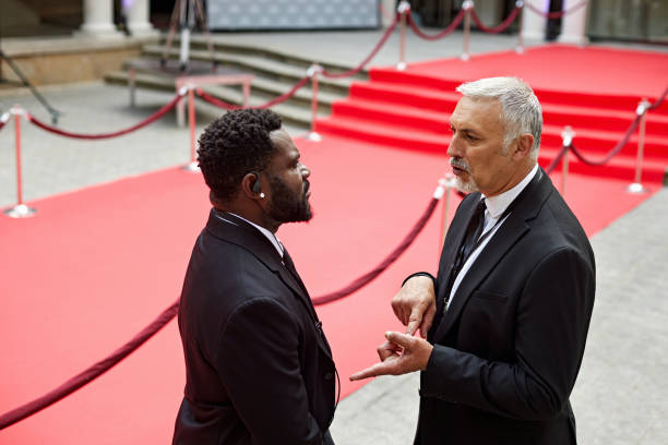 istock Male security guards discussing plans for red carpet event 2166582878