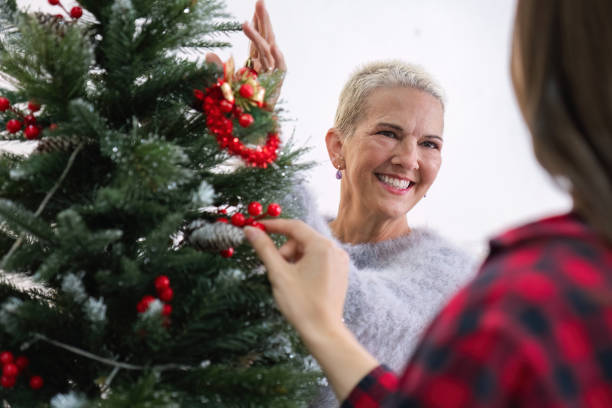 istock Mother and Daughter Joyfully Decorating Christmas Tree Together in Cozy Home Setting 2166583161