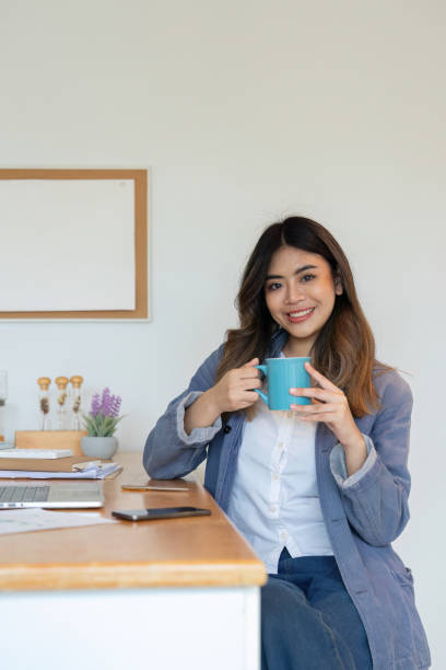 istock Young Woman Freelancer Working from Home with Laptop and Coffee in Modern Home Office Setting 2166583502