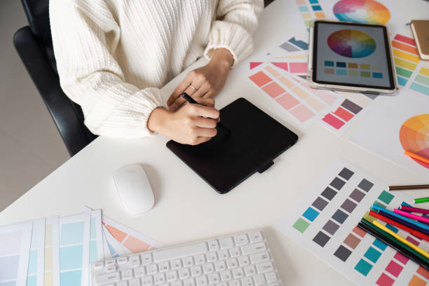 istock Creative Designer Working on Digital Tablet Surrounded by Color Swatch and Design Tools in Modern Workspace 2166583557