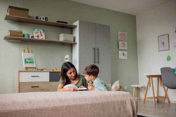 istock Mother reading a book to her son at home 2166584743