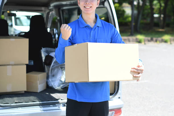 istock An Asian male delivery driver makes a fist pump while holding a package. 2166585440