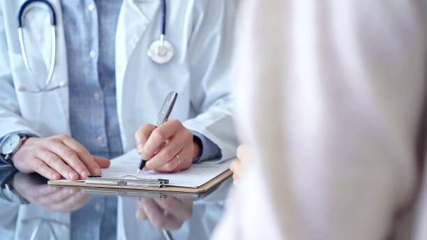 istock Doctor and patient conversation with clipboard in clinic office. Physician is making notes while listening woman. Medicine and Health care 2166586395