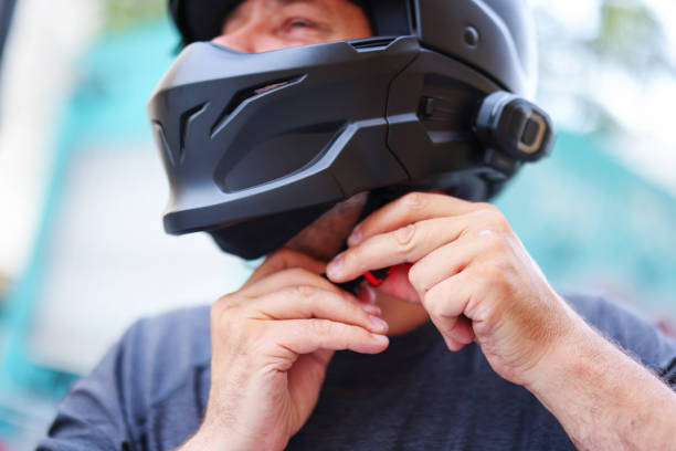 man fastens a black helmet on his head