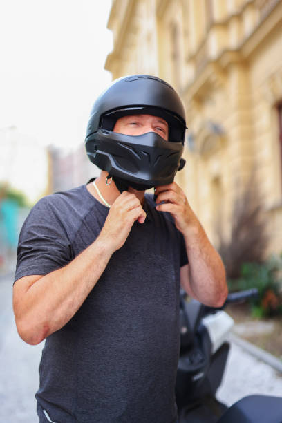 istock Man racer puts on a black helmet before a race car race 2166586599