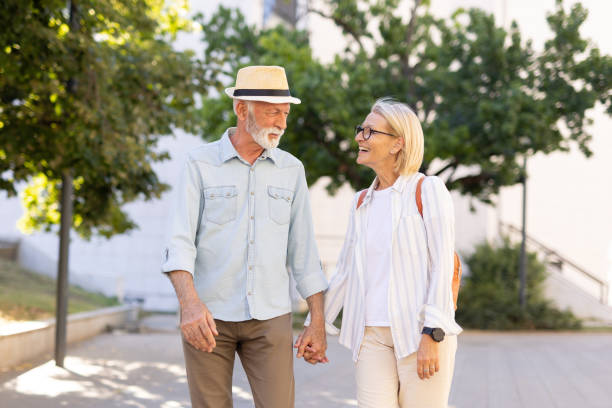istock Senior couple holding hands while walking in a park happily 2166586638