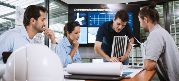 Engineer team brainstorm meeting in factory office. Presentation on ESG project planning, solar panel, wind turbine power generation, environmental sustainable energy efficient. Industrial business