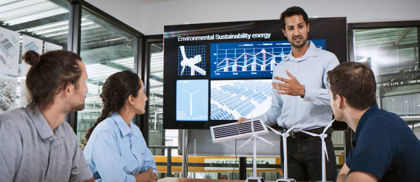 Engineer team brainstorm meeting in factory office. Presentation on ESG project planning, solar panel, wind turbine power generation, environmental sustainable energy efficient. Industrial business